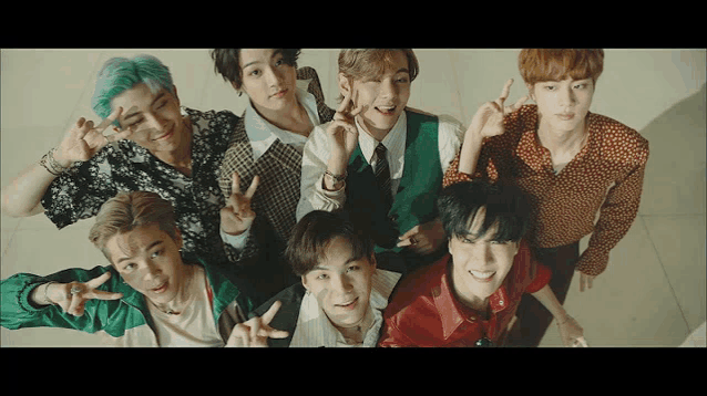 a group of young men posing for a picture and giving the peace sign