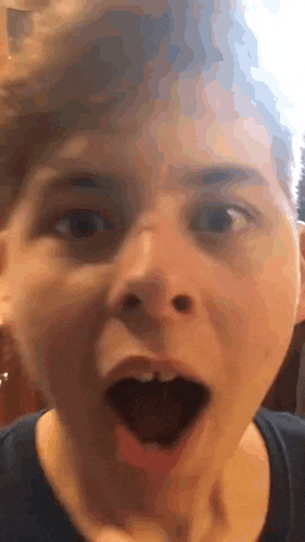 a close up of a person 's face with a surprised look on his face