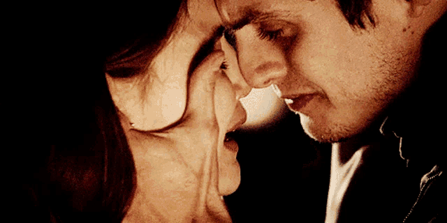 a close up of a man and a woman touching their noses