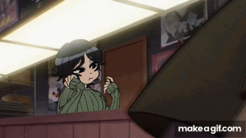 a girl in a green sweater is looking out of a window in a room .