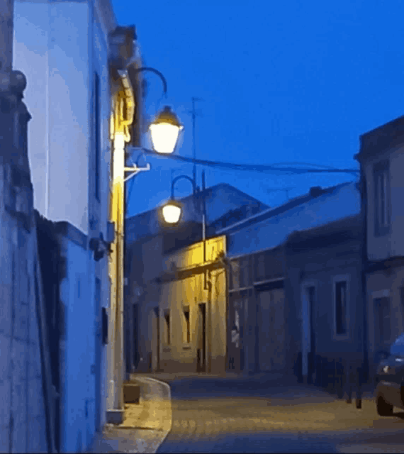 a narrow street with a few buildings and a lamp post