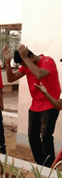 a man in a red shirt is doing a dab with his hands
