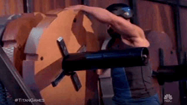 a man is standing in front of a large machine with his arm outstretched .