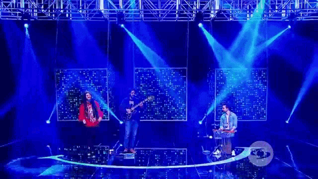 a group of people are on a stage with blue lights