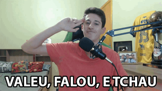 a man sitting in front of a microphone with the words " valeu falou etchau " written below him