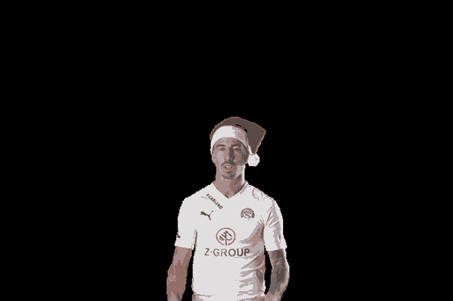 a man wearing a santa hat is wearing a z group shirt