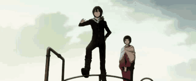 a man and a woman are standing on top of a metal structure .