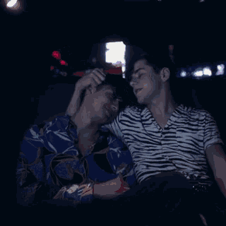 a man in a zebra print shirt sits next to another man