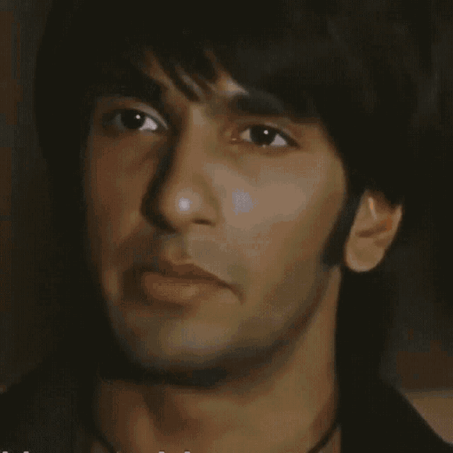 a close up of a man 's face with a black shirt