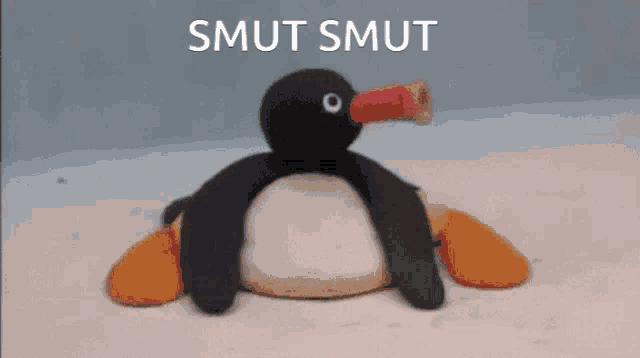 a stuffed penguin with a cup in its beak and the words smut smut on the bottom
