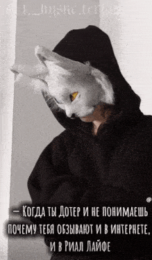 a person wearing a black hoodie and a white mask