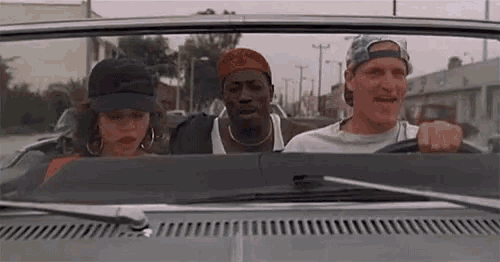 a man and a woman are sitting in a convertible car .