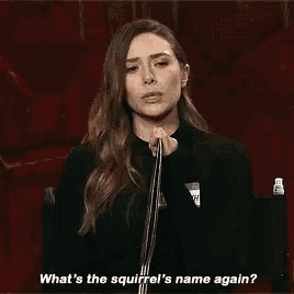 a woman is talking into a microphone and saying `` what 's the squirrel 's name again '' .