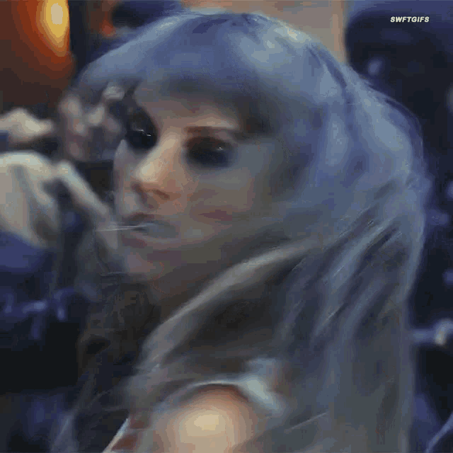 taylor swift is wearing a blue wig and looking at the camera .