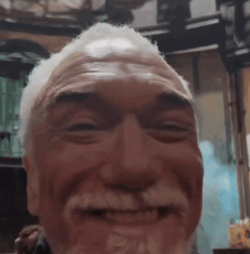 a close up of an older man 's face with a beard