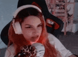 a girl with red hair is wearing headphones while sitting in a chair .