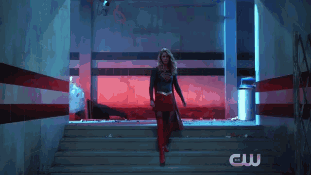 a woman in a superman costume stands on a set of stairs