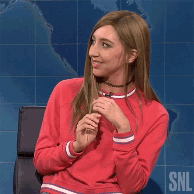 a woman sitting in front of a snl logo says stop