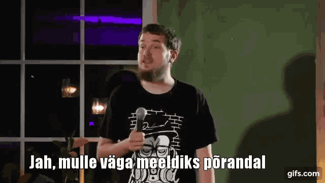a man with a beard is holding a microphone and saying jah