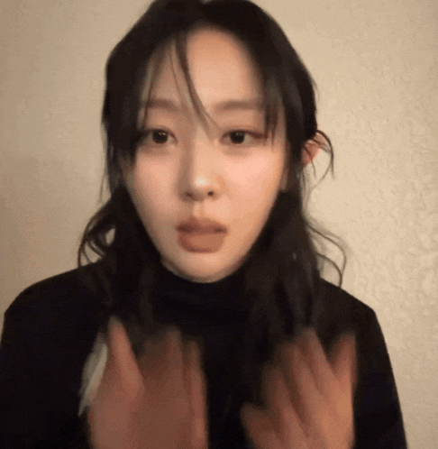 a woman in a black turtleneck sweater is making a funny face