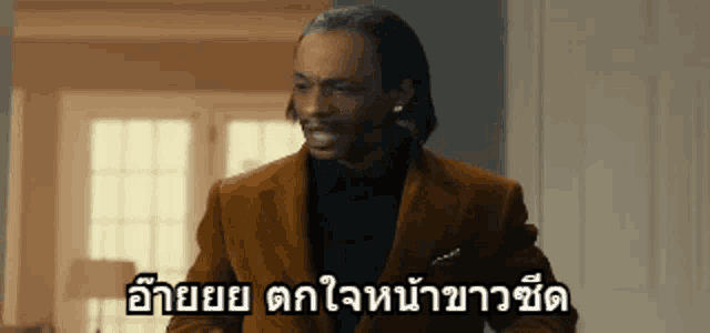 a man in a suit is standing in front of a window with a foreign language caption