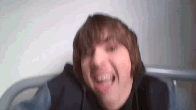 a blurry picture of a man with a hoodie on smiling