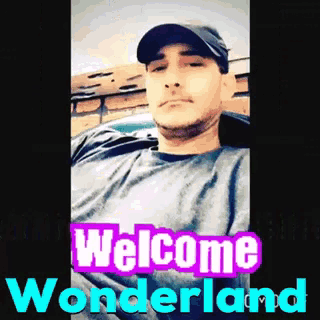 a man wearing a hat and a t-shirt with the words welcome wonderland above him
