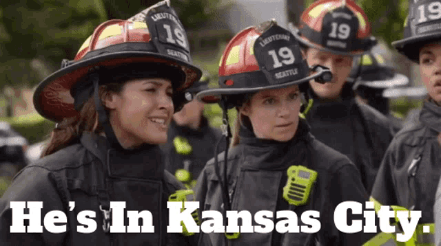 a group of firefighters standing next to each other with the words he 's in kansas city below them