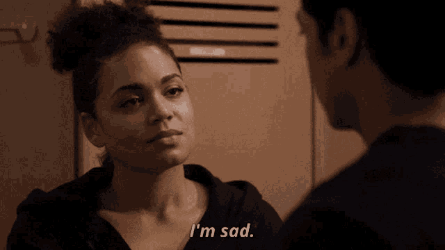a man and woman are looking at each other and the woman says i 'm sad