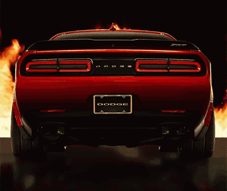the rear end of a red dodge challenger is surrounded by flames