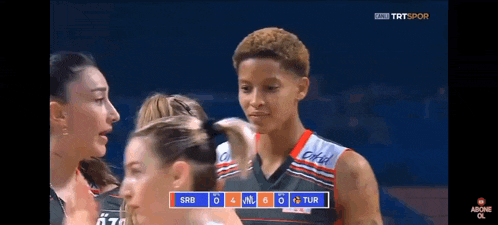 a group of female basketball players are standing in front of a scoreboard that says srb 4 m 8 tur