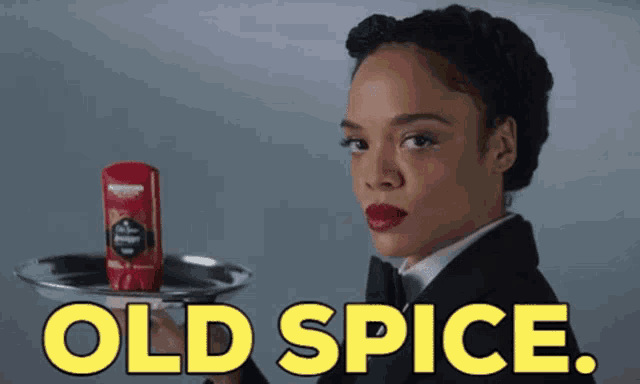 a woman in a tuxedo is holding a tray with a bottle of old spice on it
