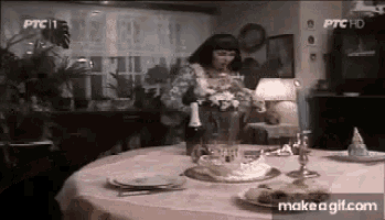 a woman sits at a table with a cake and a bottle of champagne