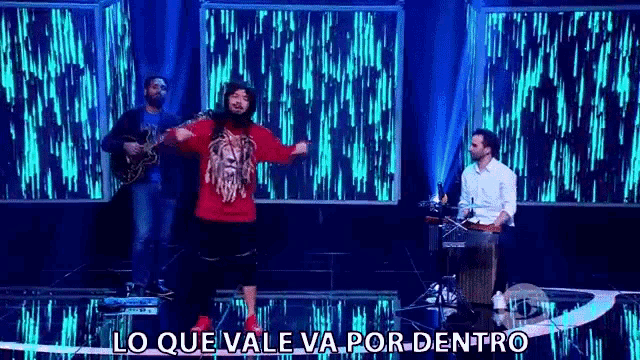 a man with a beard is dancing on a stage in front of a group of people .