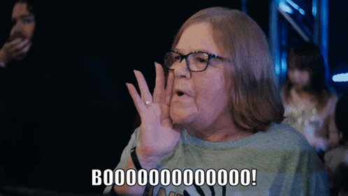 a woman wearing glasses and a blue shirt says booo