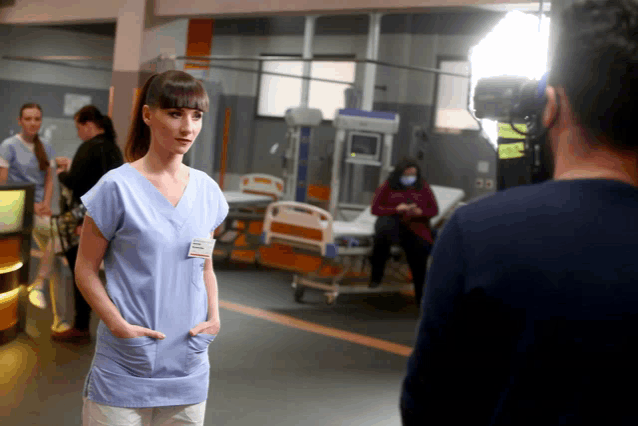 a woman in a blue scrub has a name tag on her chest that says ' petra '