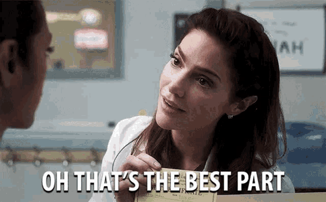 a woman in a white coat is talking to another woman in a hospital room and holding a box .