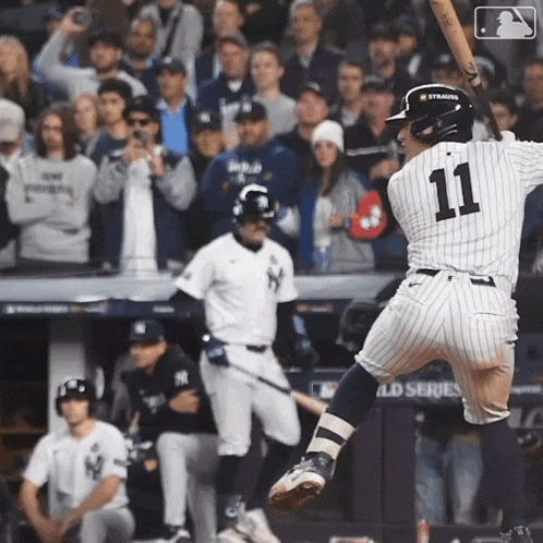 a baseball player with the number 11 on his jersey swings his bat