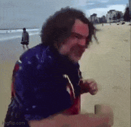 a man in a blue shirt is running on the beach