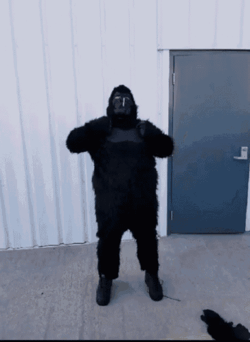 a man in a gorilla costume is standing in front of a building