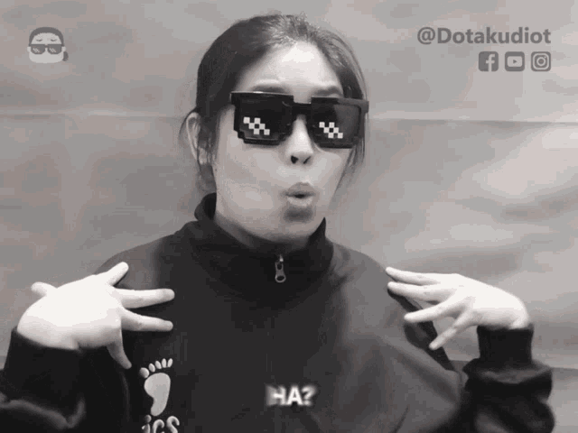 a black and white photo of a woman wearing sunglasses and a sweater that says ics