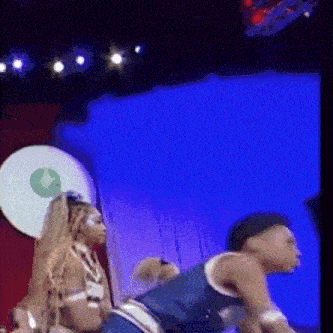 a man and a woman are dancing on a stage in front of a blue background .