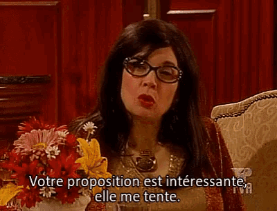 a woman sitting on a couch with a bouquet of flowers says votre proposition est interessante