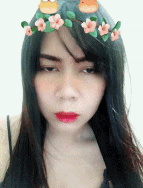 a woman with a flower crown on her head looks at the camera