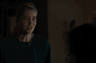a man and a woman are standing next to each other in the dark .