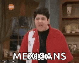a man in a red and white shirt is standing in a living room with the words mexicans written on the screen .