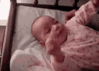 a baby is laying on a bed being held by a woman .