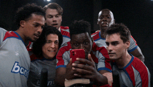 a group of soccer players are taking a selfie with a phone that says bank on it
