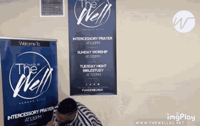 a man stands in front of a sign that says " welcome to church at the well "