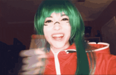 a woman with green hair is smiling and holding a bottle